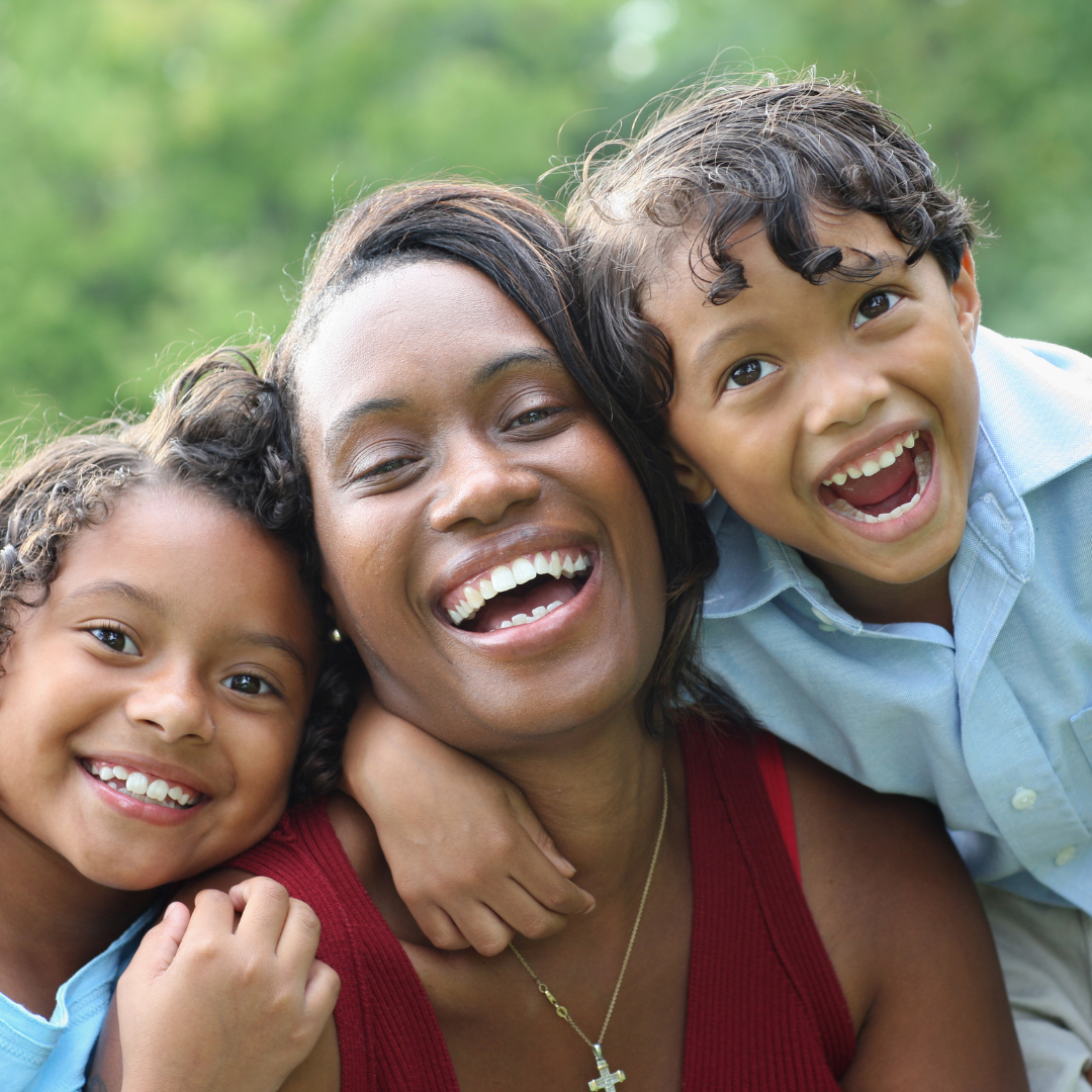 Three generations of women smiling together on a couch